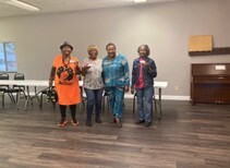 Four women receiving gift cards from the Inter-Faith shuttle