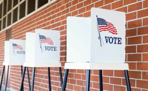 Voter poll stations set up against a wall.