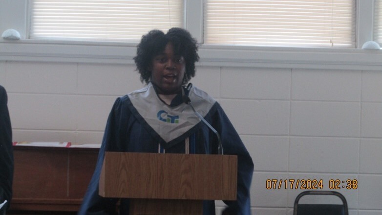 A graduate speaking at the podium.