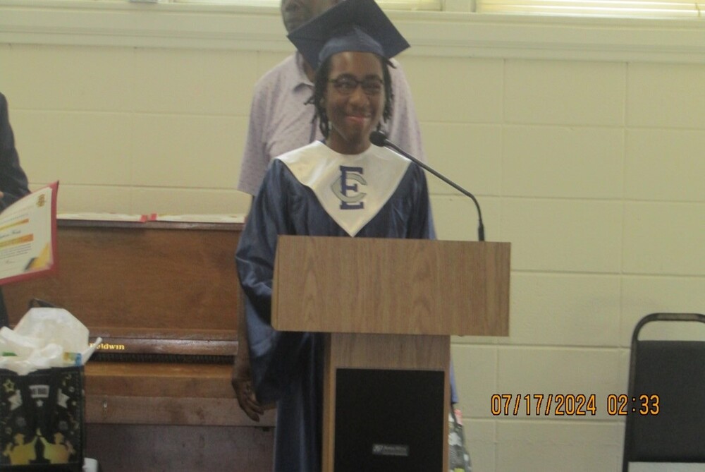 A smiling person standing behind the podium.