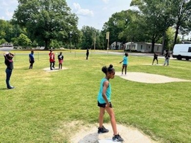 Groups of kids outside playing ball.