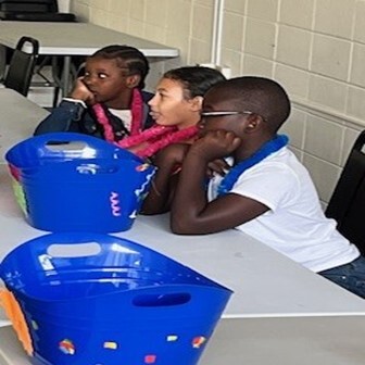 Some kids sitting at a table with their fun buckets.