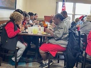 Individuals eating at a table.