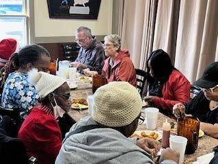 Close up of individuals eating at a table.