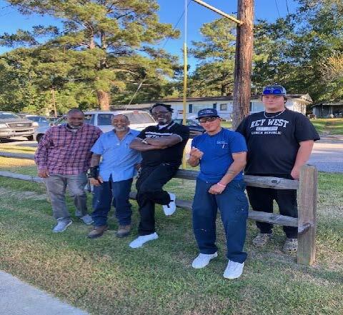 A group of individuals standing by a fence.