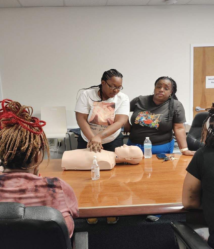 Individuals practicing CPR on a test dummy.