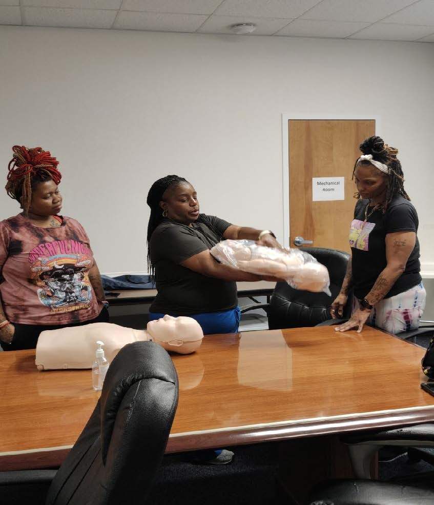 Three women practicing CPR.