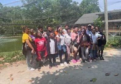 A group of children and adults standing outside.